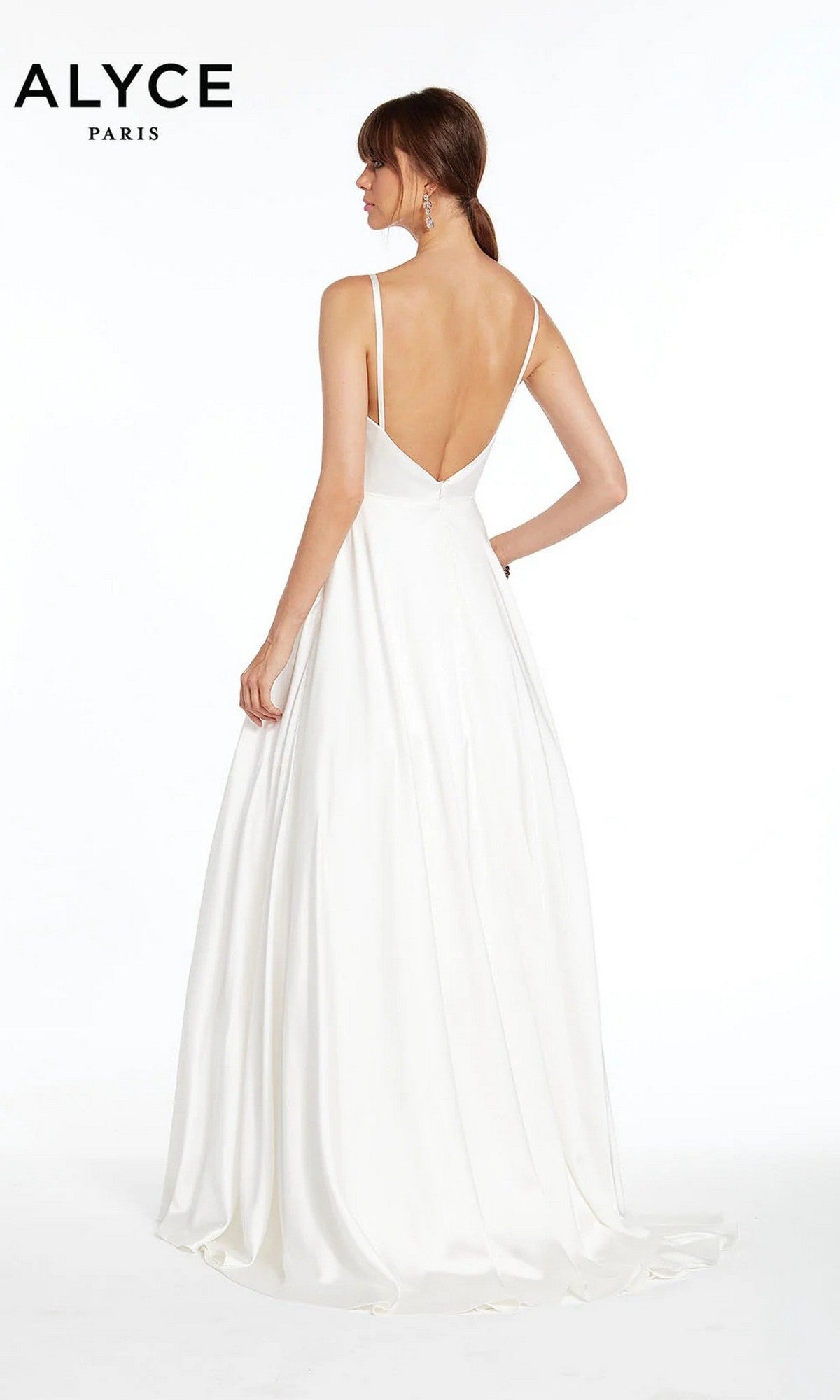 A woman models the Alyce 7009 long white dress—a sleeveless, floor-length minimalist gown with a deep V-back—standing against a plain white background. The